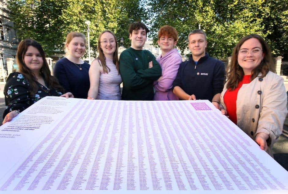 Young people holding giant postcard prop